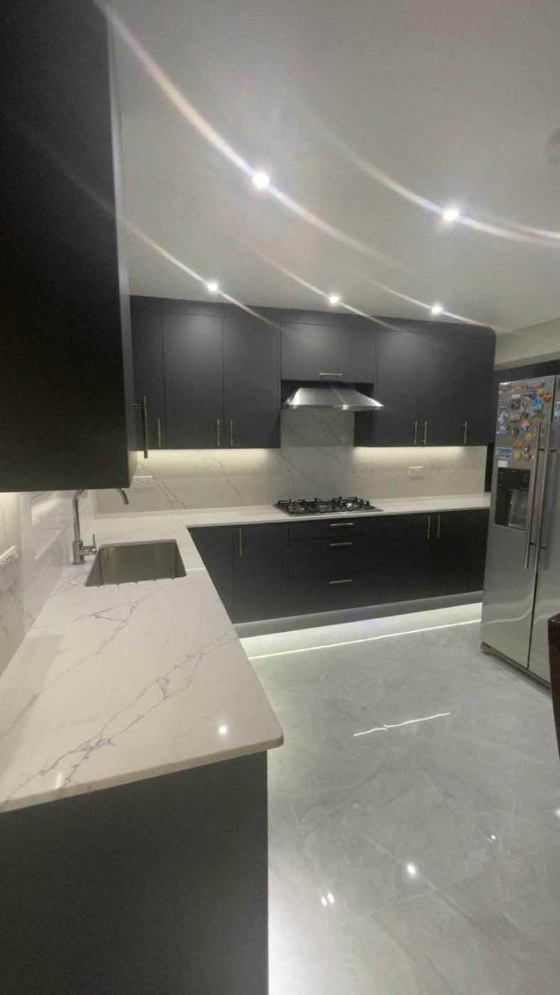 Dark kitchen with LED plinth lighting by Kulwant Carpentry