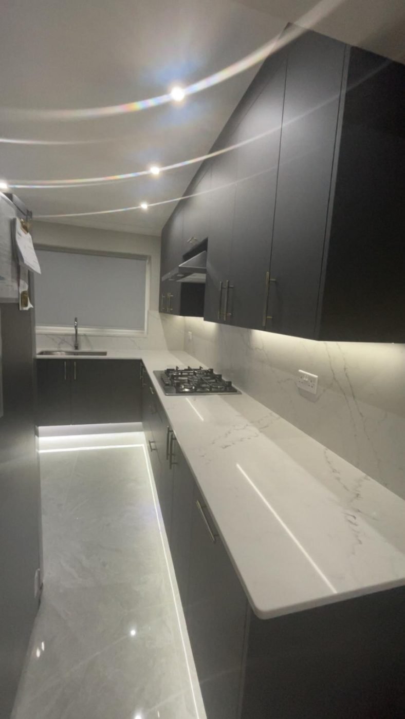 Dark kitchen with marble-effect worktops fitted by Kulwant Carpentry